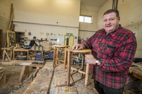 Man crafting a stool out of wood