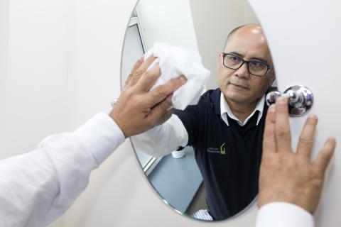 Man cleaning a mirror