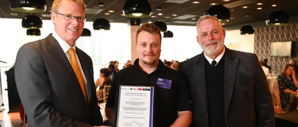 three men holding an awards