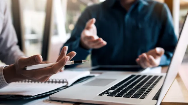 2 people having a dispute looking at a laptop