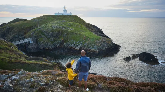 family looking at a lighthouse