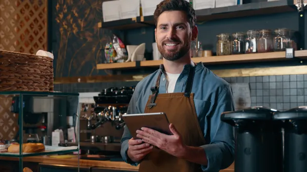 Small Business owner looking at a digital device 