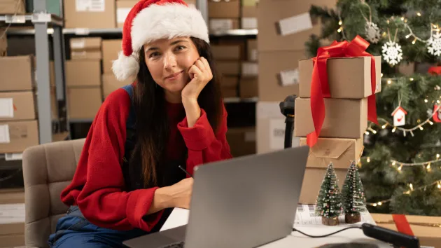 Employer looking at a digital device wearing a Christmas hat 