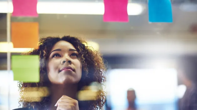 Female looking at post it notes 