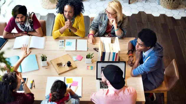 colleagues sitting around a table - team learning