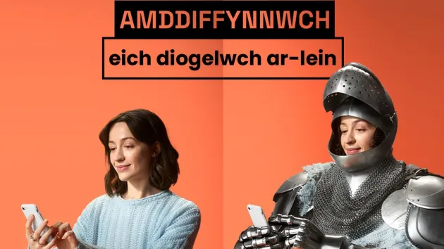 Cyber security - woman wearing a suit of armour looking at a digital device 