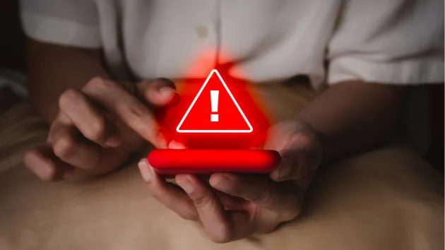 mobile phone and a warning sign in red