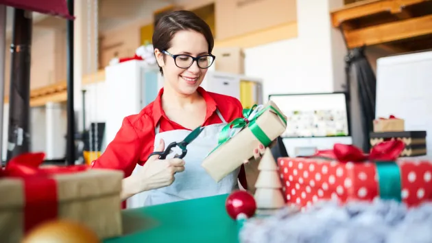 person wrapping Christmas presents 