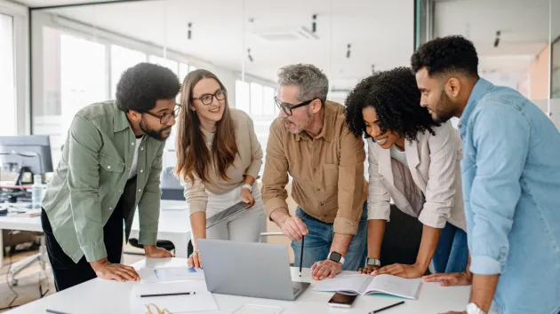 Business team looking at a laptop in an office