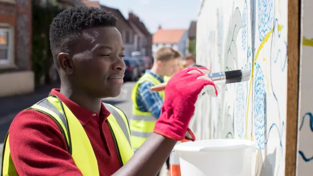 Young volunteer painting in the community