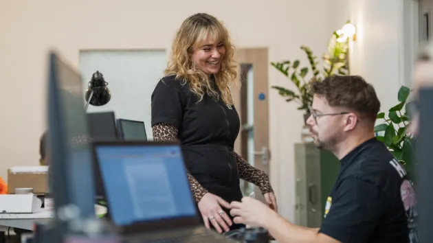 Colleagues discussing over laptop