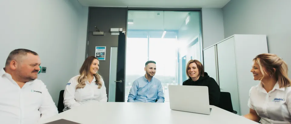 Team sat at a table talking in an office setting