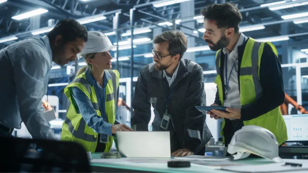 Engineers looking at a digital device 