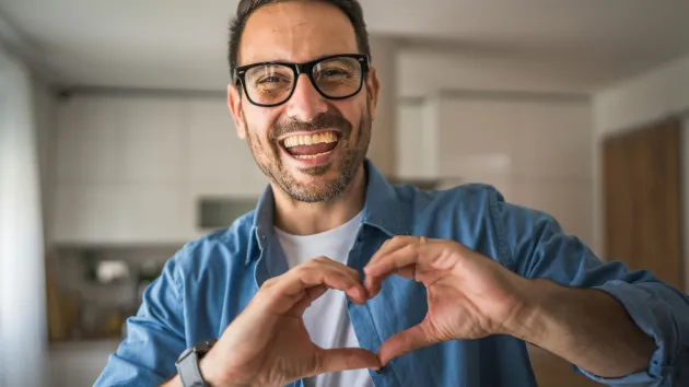 man holding hands in a heart shape 