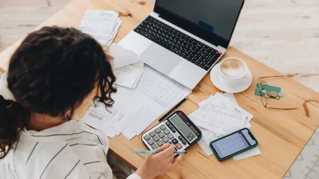 Person using a calculator, tax invoices