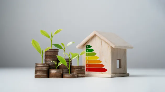 Stacked coins, house with energy efficiency graph 