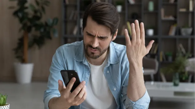 stressed business person looking at a mobile phone 