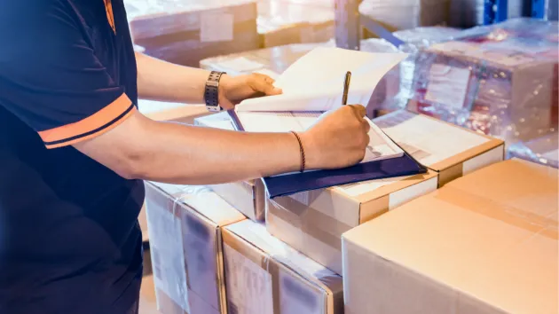 person filling out paperwork for sending parcels