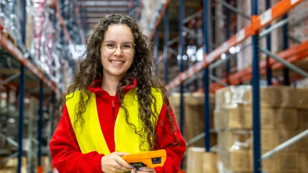 Warehouse worker wearing a red jumper and yellow vest 