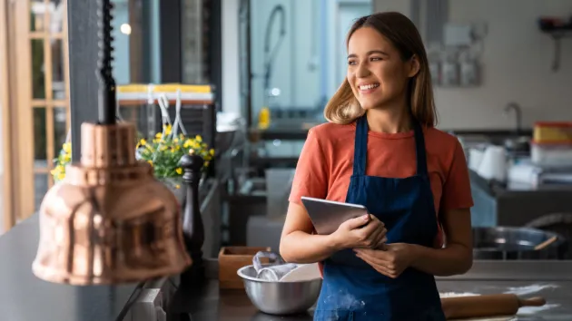 female business owner looking at a digital device 
