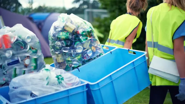 Staff at a festival recycling bottles and cans