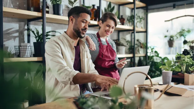 small business owner - florist - looking at a digital device 