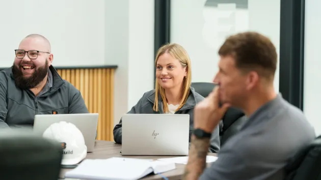 Team smiling and discussing around a table
