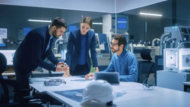 Diverse Team of Engineers, Managers Talking at Conference Table