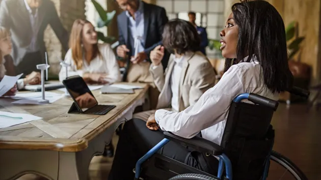 business colleagues, one colleague is a wheelchair user