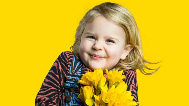 girl holding a bunch of daffodils