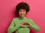 female holding her hands in a heart shape