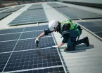 Engineer fixing solar panels to roof 