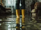 person wearing wellington boots and stood in a flooded sitting room