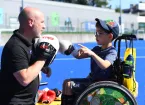 child wheelchair user boxing with an instructor 