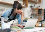 Small business owner looking at a digital device 