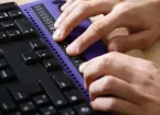 person using braille and computer