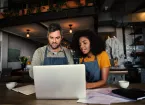 Small Business Owners looking at a digital device