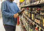 Person buying a bottle of wine at a supermarket 