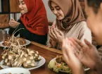 Muslim women and men praying before eating
