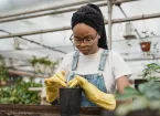 A Girl Putting Soil In A Pot