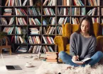 Young woman writer in library at home creative occupation sitting writing notes