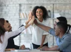 successful businesswoman with business people giving high five, celebrating win. 