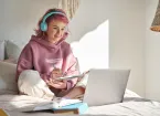  teen girl school student with pink hair wear headphone write notes watching video online webinar