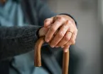 mature woman hands holding handle of walking stick