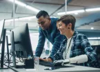 Project Manager Talks with Happy Woman with Disability with Prosthetic Arm to Work on Desktop Computer