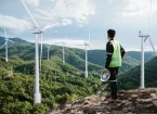 Young maintenance engineer man working in wind turbine on the mountain,power generation saving and using renewable energy concept.