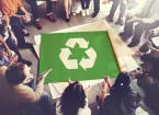Colleagues gathered around a recycling poster 