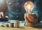 lightbulb and a stack of coins