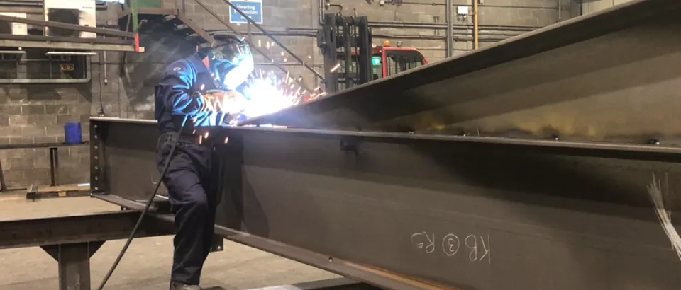 worker using machinery with sparks 